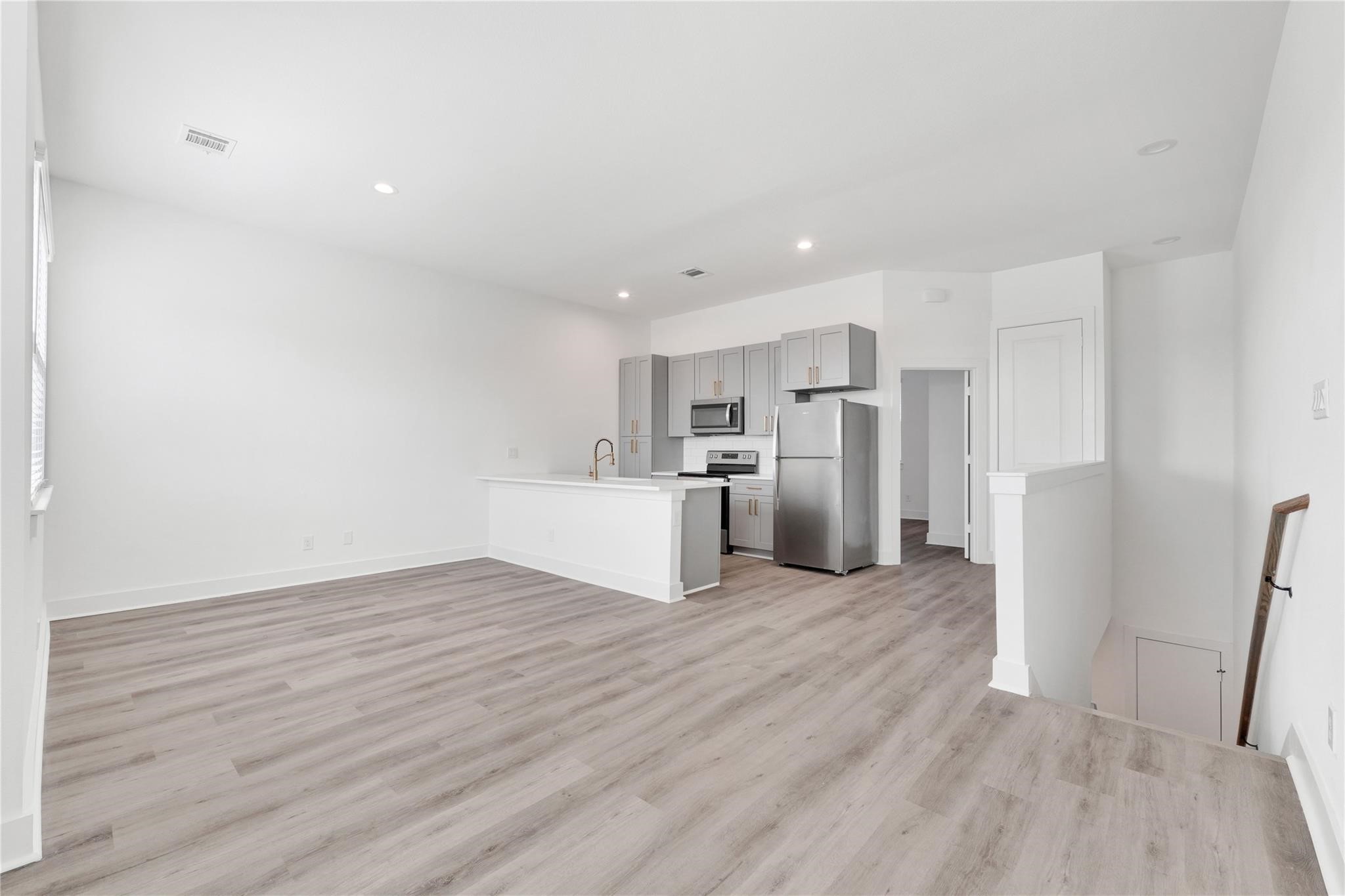 3210 Frying Pan Place, Unit B Katy, TX 77449 - Photo 11 of 49 a view of kitchen with refrigerator microwave and wooden floor