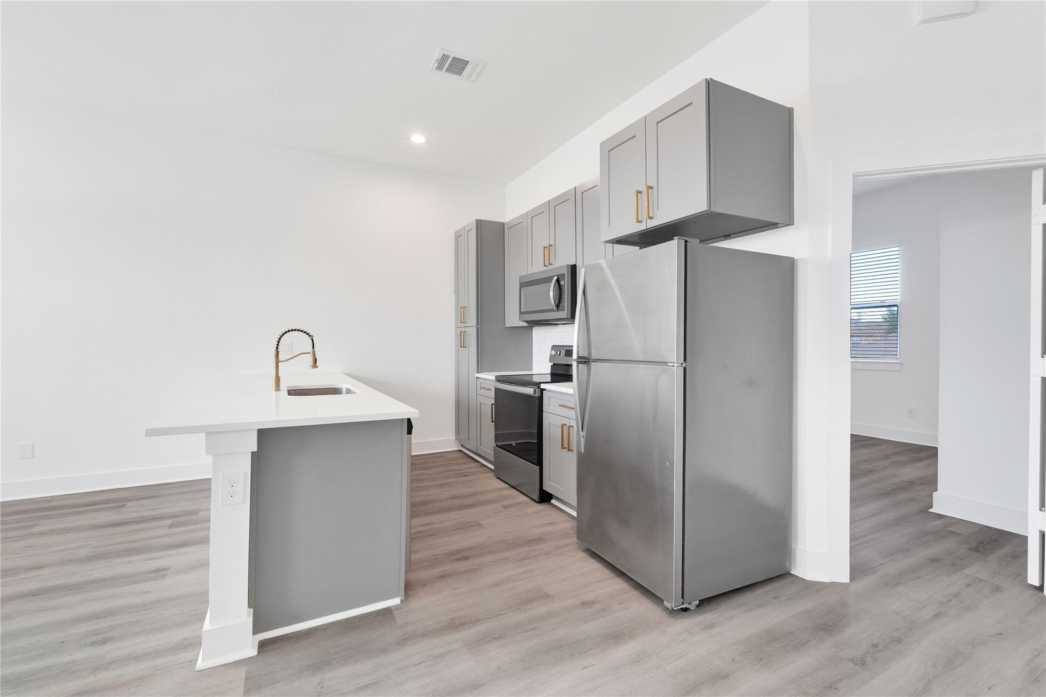 3210 Frying Pan Place, Unit B Katy, TX 77449 - Photo 15 of 49 a kitchen with stainless steel appliances a refrigerator and a sink