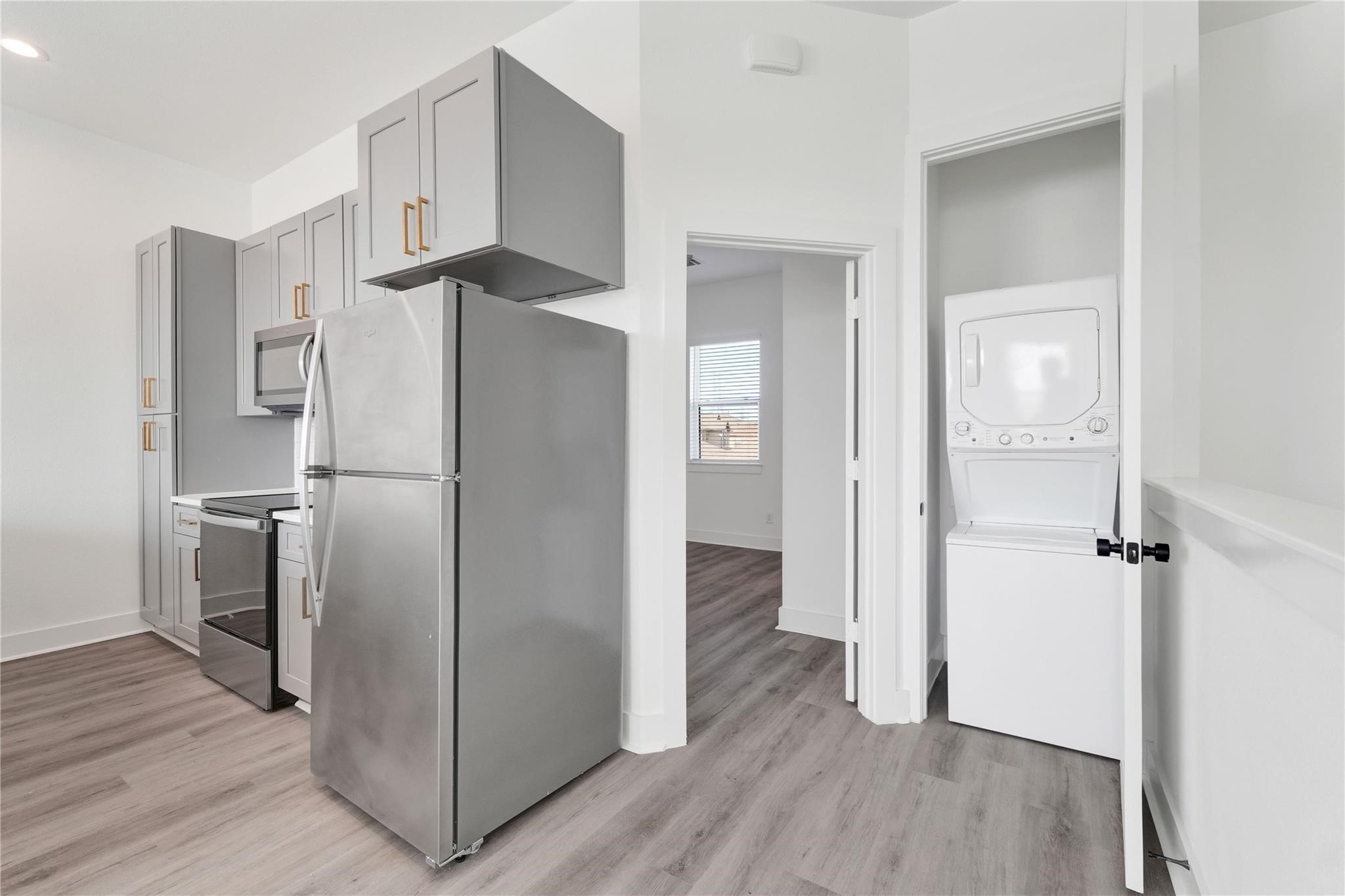 3210 Frying Pan Place, Unit B Katy, TX 77449 - Photo 18 of 49 a kitchen with stainless steel appliances a refrigerator and wooden floor