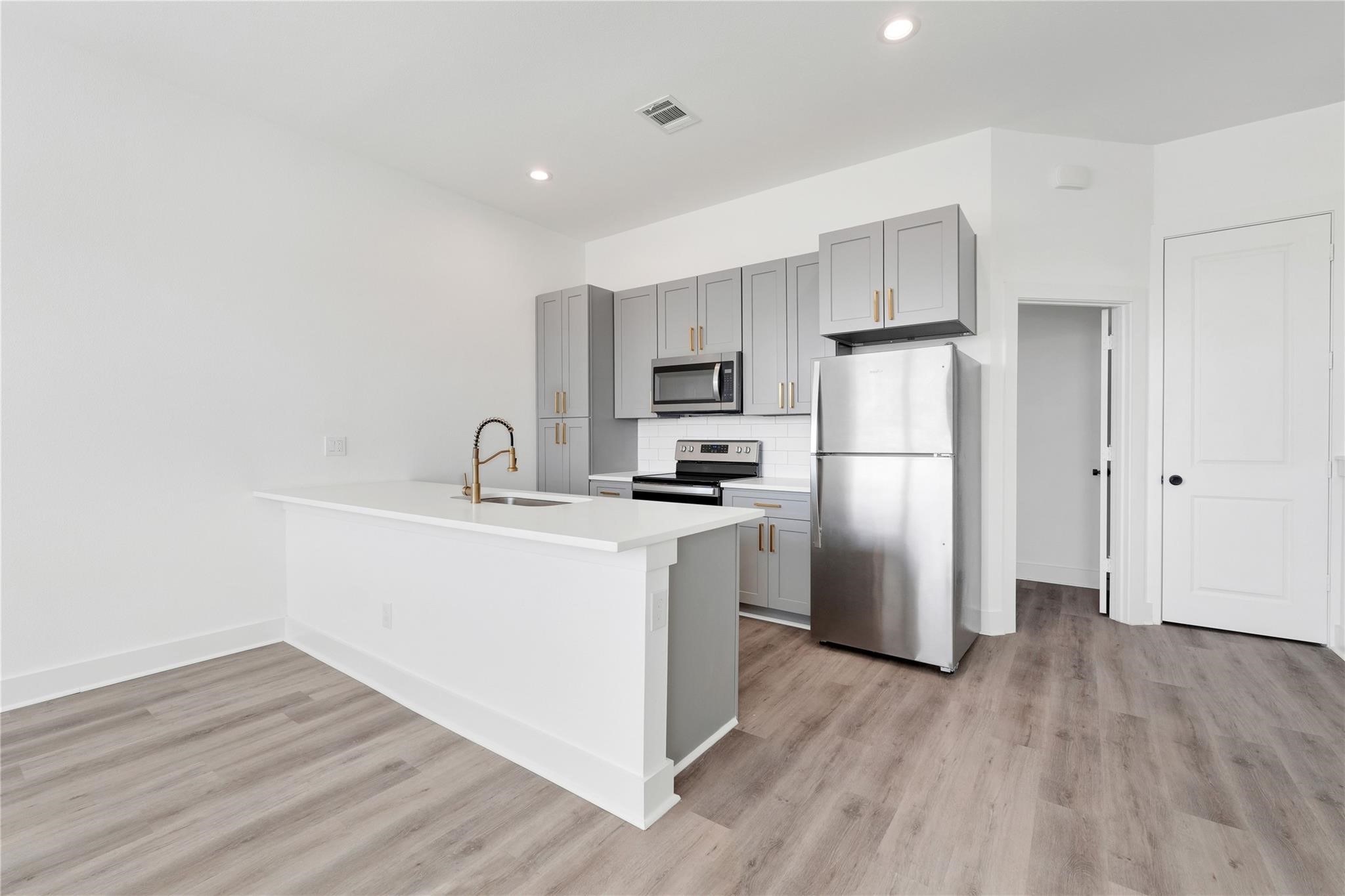 3210 Frying Pan Place, Unit B Katy, TX 77449 - Photo 21 of 49 a kitchen with a refrigerator a sink and wooden floor
