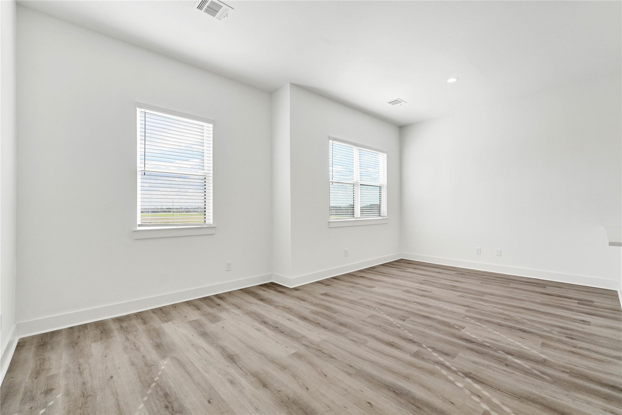 3210 Frying Pan Place, Unit B Katy, TX 77449 - Photo 26 of 49 an empty room with wooden floor and windows