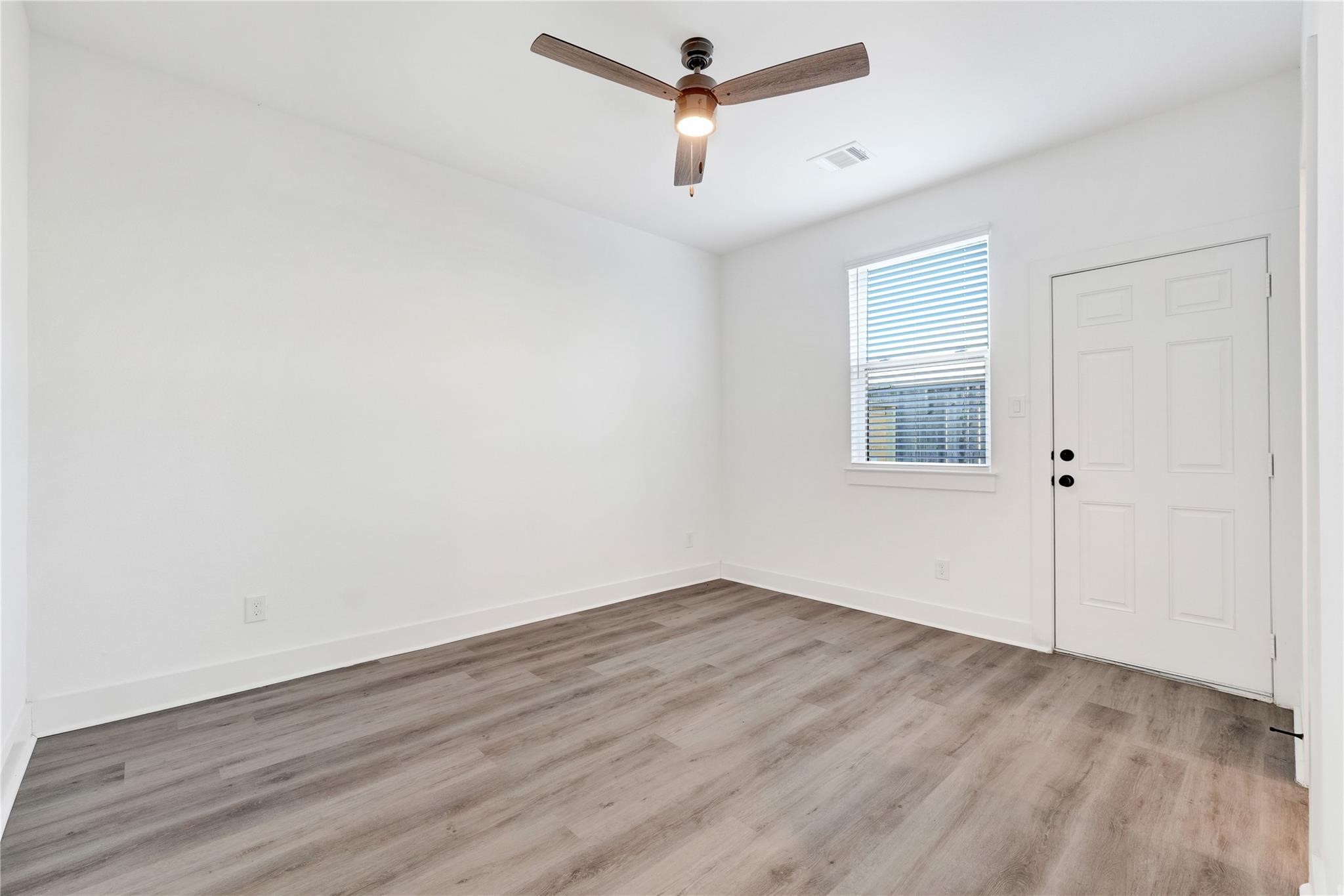 3210 Frying Pan Place, Unit B Katy, TX 77449 - Photo 28 of 49 an empty room with wooden floor ceiling fan and windows