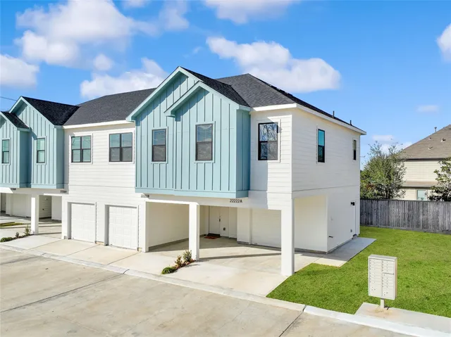 a view of a house with a patio and a yard