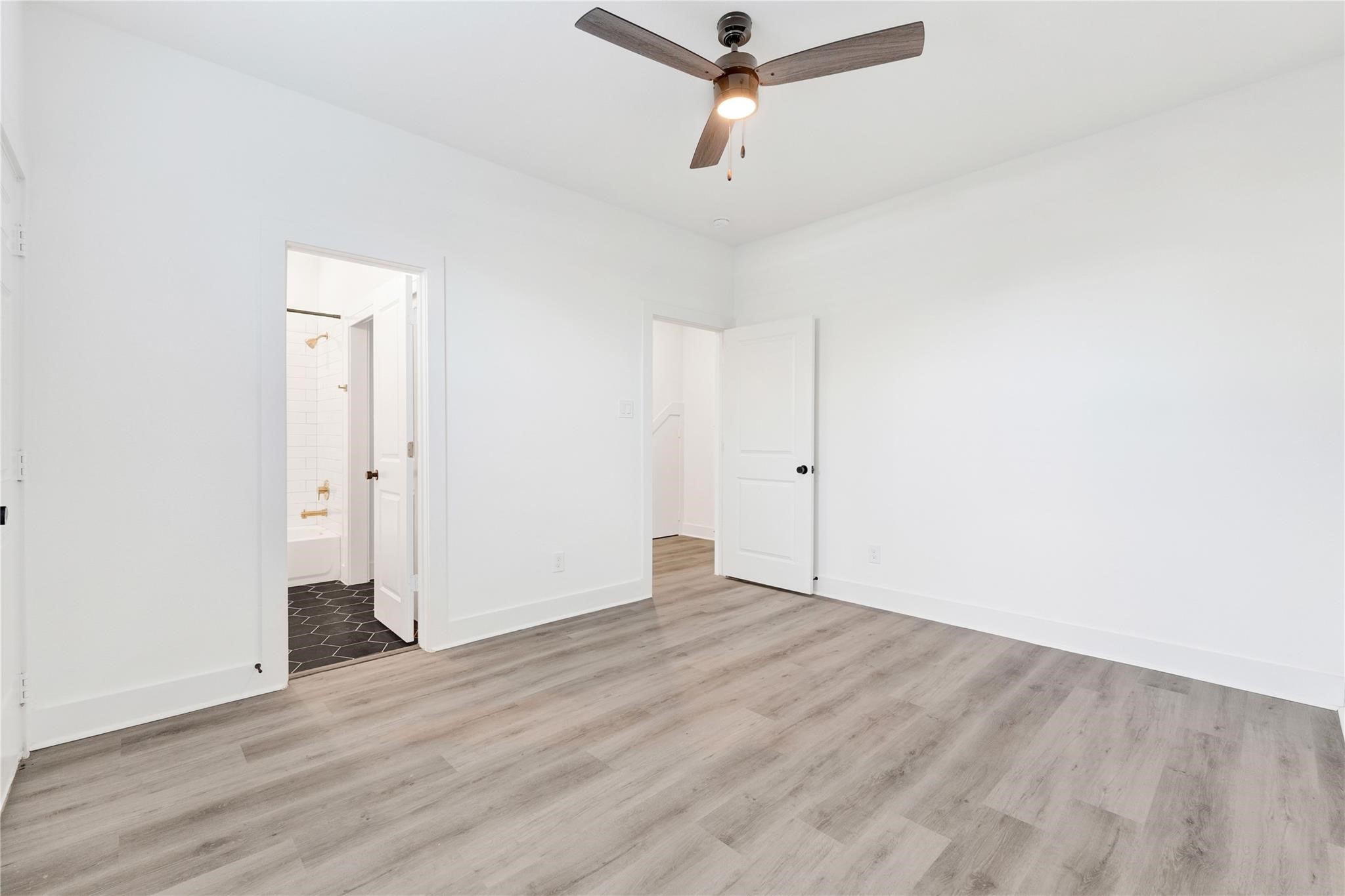 3210 Frying Pan Place, Unit B Katy, TX 77449 - Photo 31 of 49 an empty room with wooden floor cabinet and ceiling fan