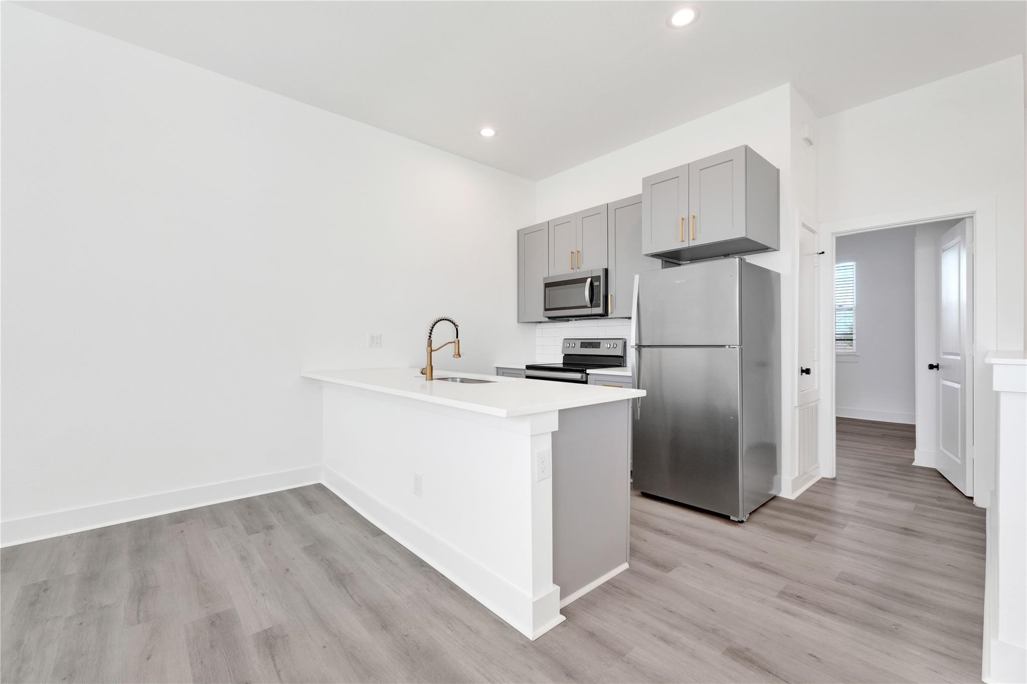 3210 Frying Pan Place, Unit B Katy, TX 77449 - Photo 10 of 49 a kitchen with a refrigerator sink and cabinets
