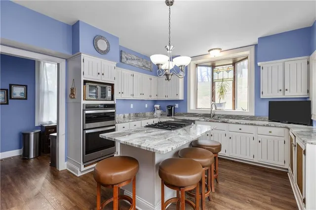 a kitchen with stainless steel appliances granite countertop a stove a refrigerator and a sink