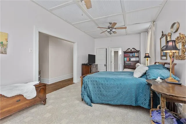 a bedroom with a bed a ceiling fan and a rug