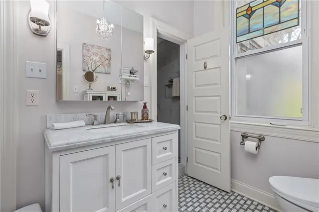 a bathroom with a granite countertop sink a toilet and a mirror