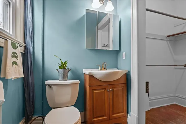 a bathroom with a toilet a sink and mirror