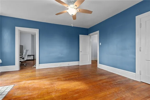 a view of an empty room with window and a kitchen
