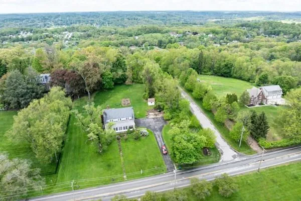 an aerial view of residential houses with outdoor space and trees