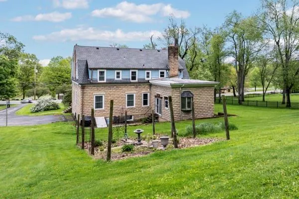 a view of an house with backyard and a tree