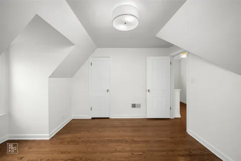a view of a room with wooden floor and chandelier