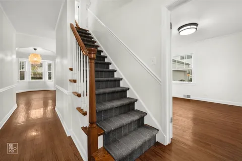 a view of a hallway with wooden floor and staircase