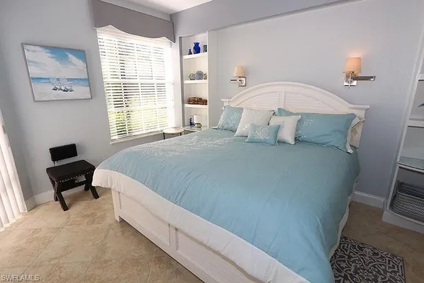 a bedroom with a bed a couch and a window