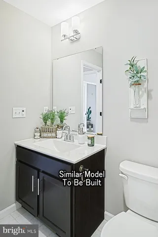 a bathroom with a granite countertop sink a toilet and mirror