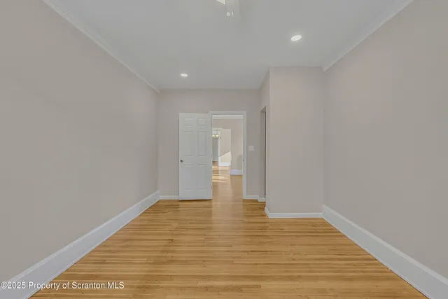 a view of empty room with wooden floor