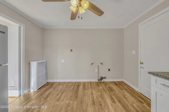 a view of empty room with wooden floor