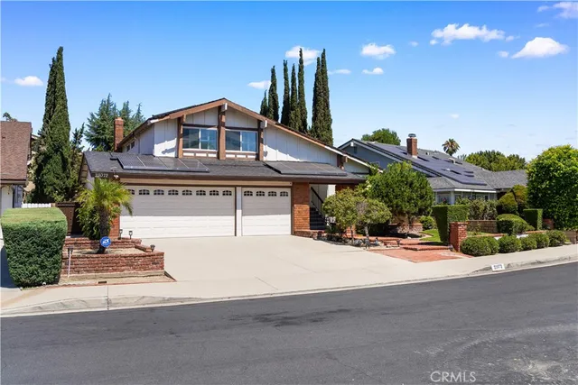 a front view of a house with a yard and potted plants