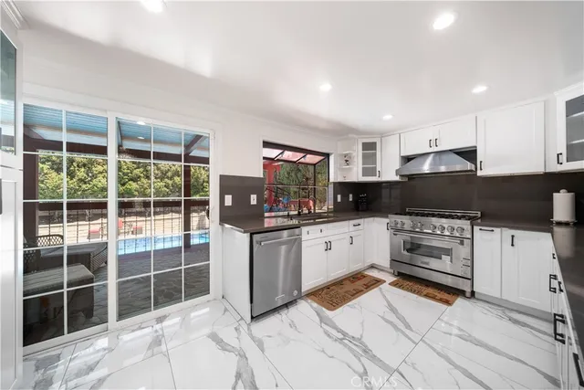 a kitchen with stainless steel appliances kitchen island granite countertop a refrigerator and a sink