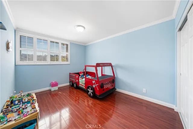 a bedroom with bed and a wooden floor