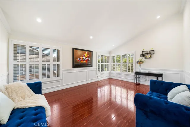 a living room with furniture floor to ceiling window and wooden floor
