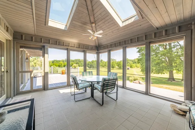 a view of a backyard with table and chairs potted plants and large tree