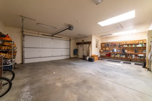 a view of a backyard with table and chairs plants and large trees