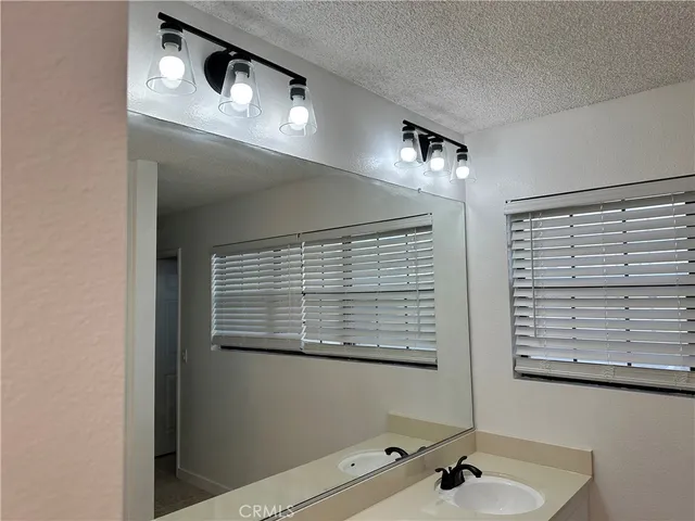 a bathroom with a sink a mirror and a window