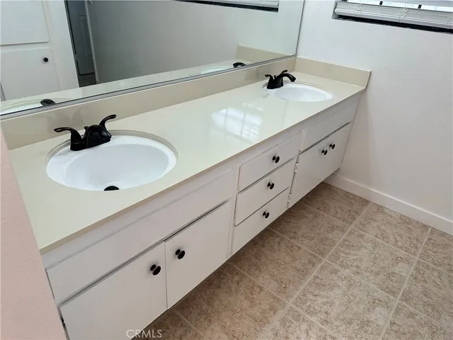 a bathroom with a double vanity sink and mirror
