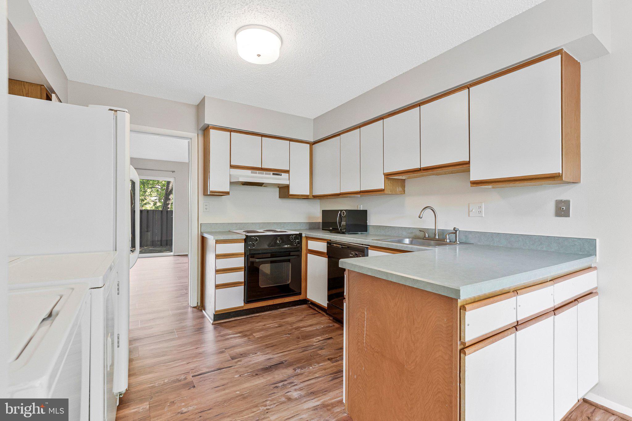 2202 Southgate Square Reston, VA 20191 - Photo 12 of 22 a kitchen with stainless steel appliances granite countertop a sink stove and refrigerator