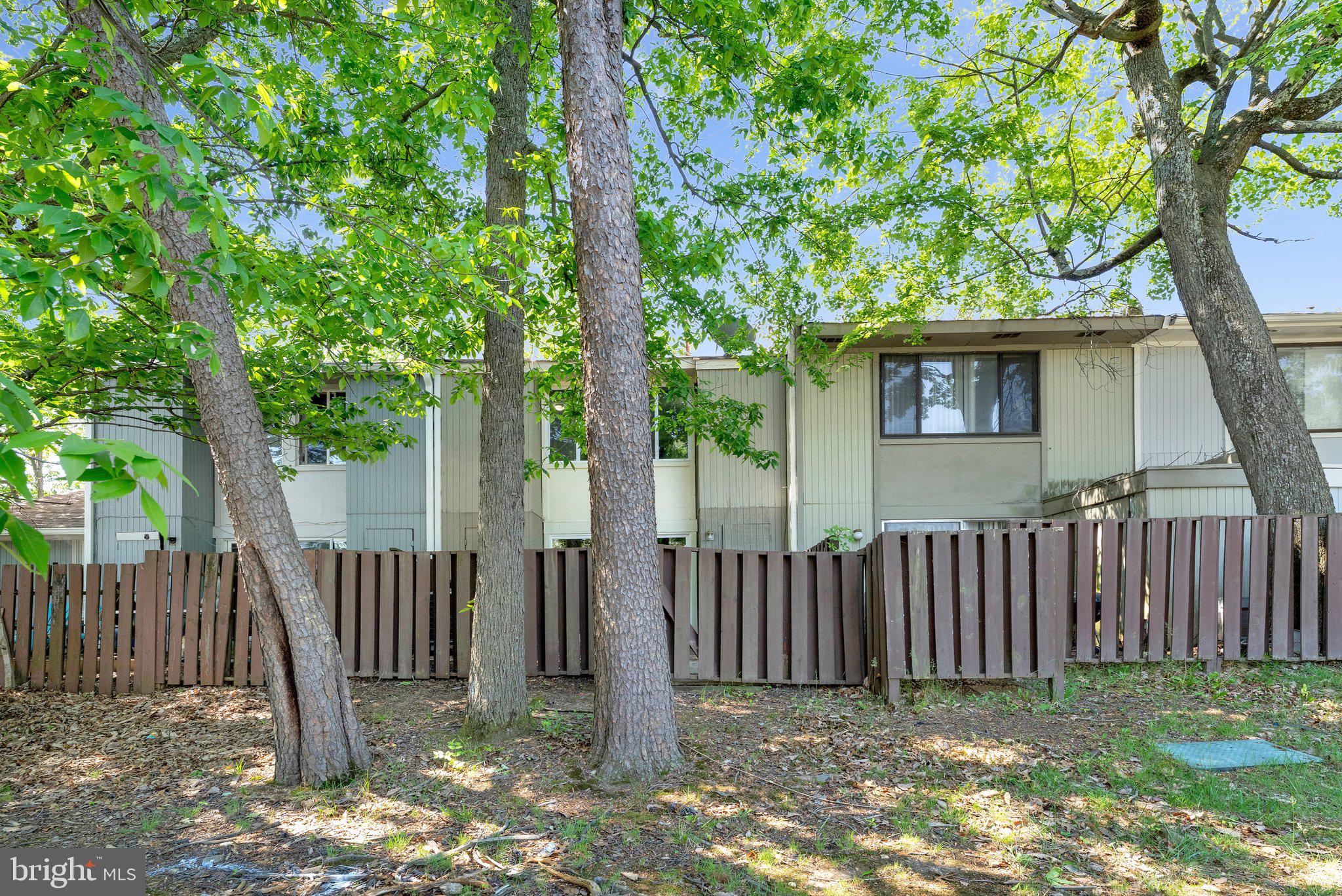 2202 Southgate Square Reston, VA 20191 - Photo 21 of 22 a view of a small yard with a large tree and wooden fence