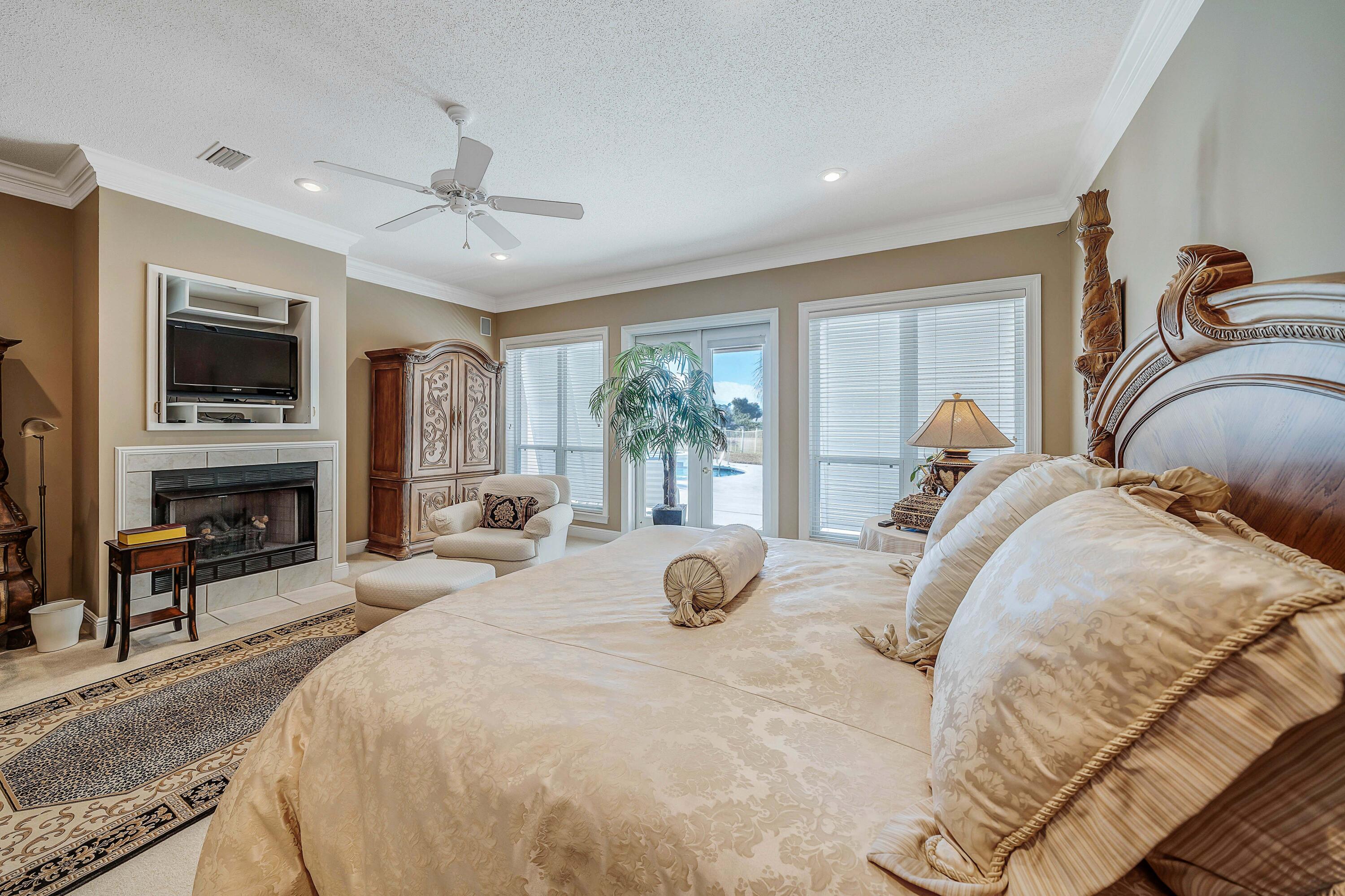 3601 Dragon's Ridge Road Panama City Beach, FL 32408 - Photo 25 of 62 a bedroom with a bed and a chandelier