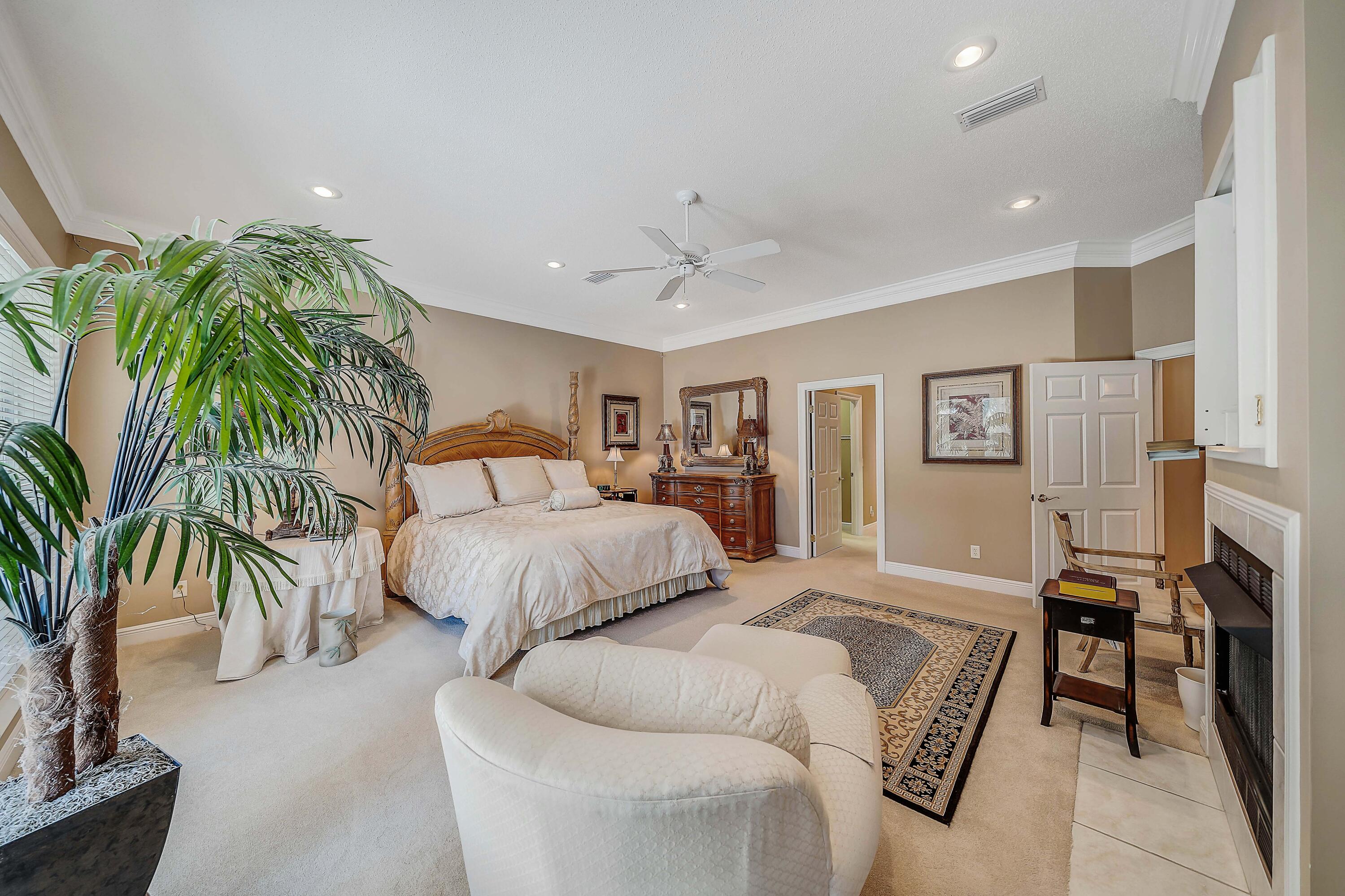 3601 Dragon's Ridge Road Panama City Beach, FL 32408 - Photo 26 of 62 a spacious bedroom with a large bed and a chandelier