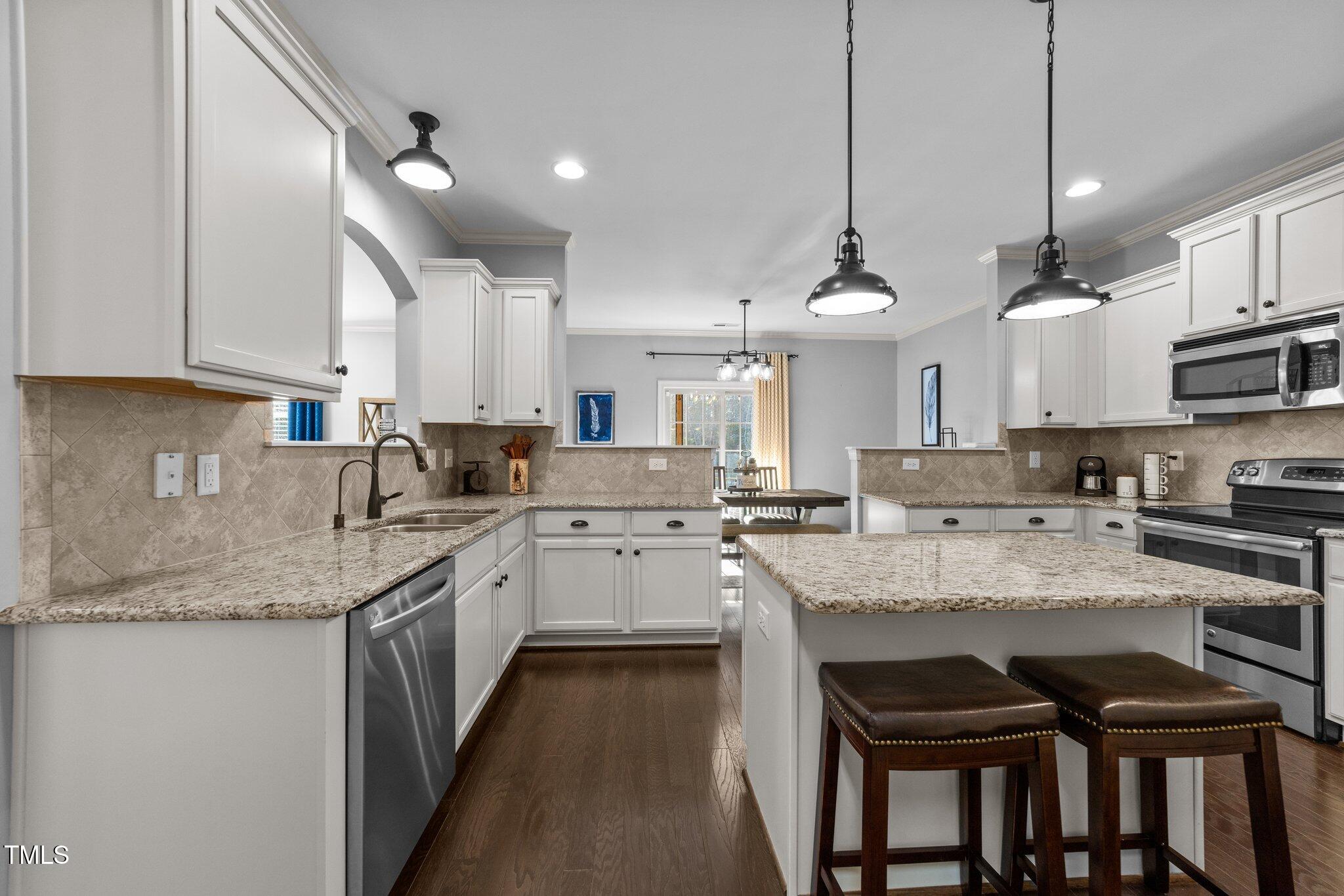 7520 Channery Way Raleigh, NC 27616 - Photo 15 of 47 a kitchen with stainless steel appliances granite countertop a sink a stove and a refrigerator