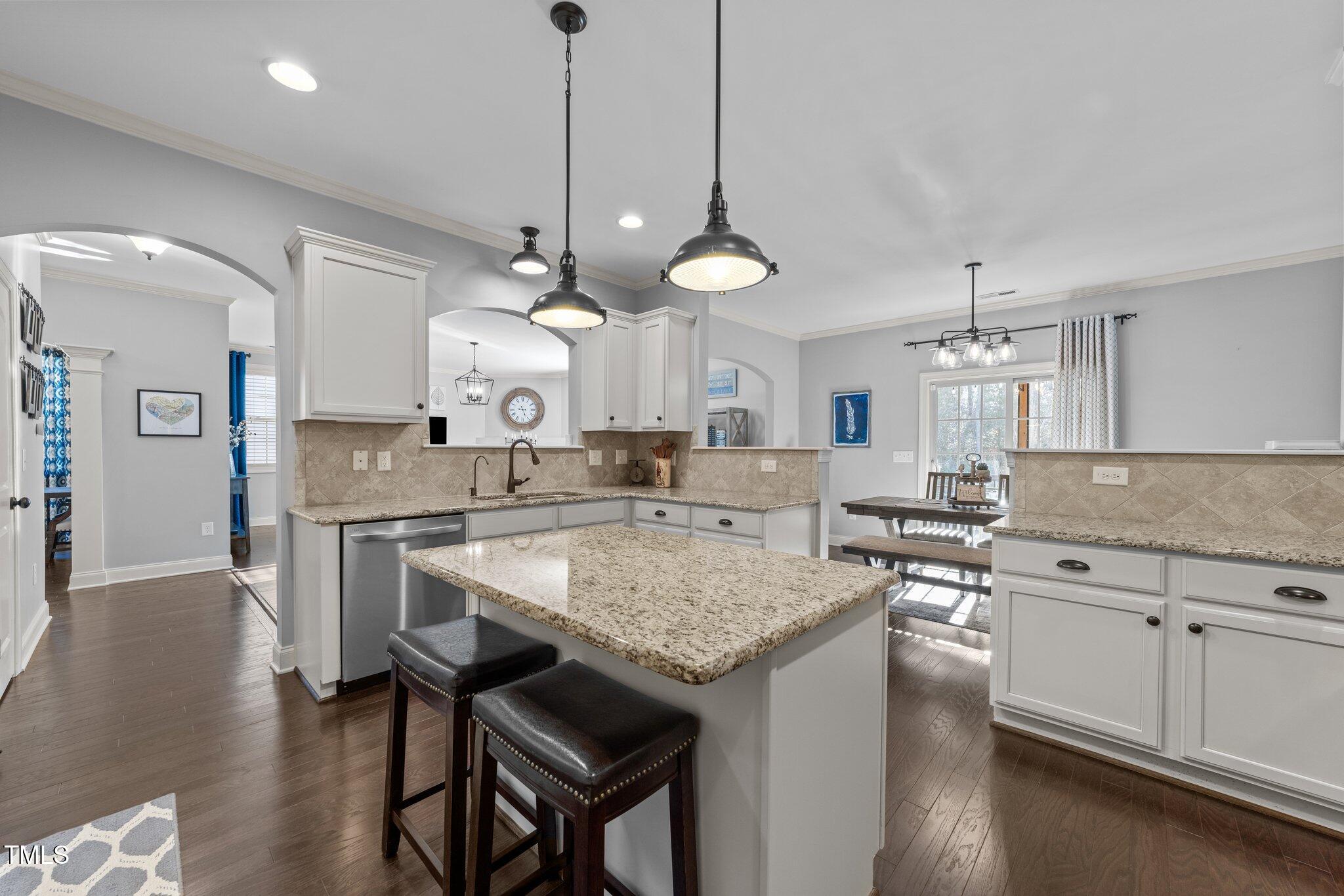 7520 Channery Way Raleigh, NC 27616 - Photo 18 of 47 a kitchen with a stove a counter space dining table and chairs