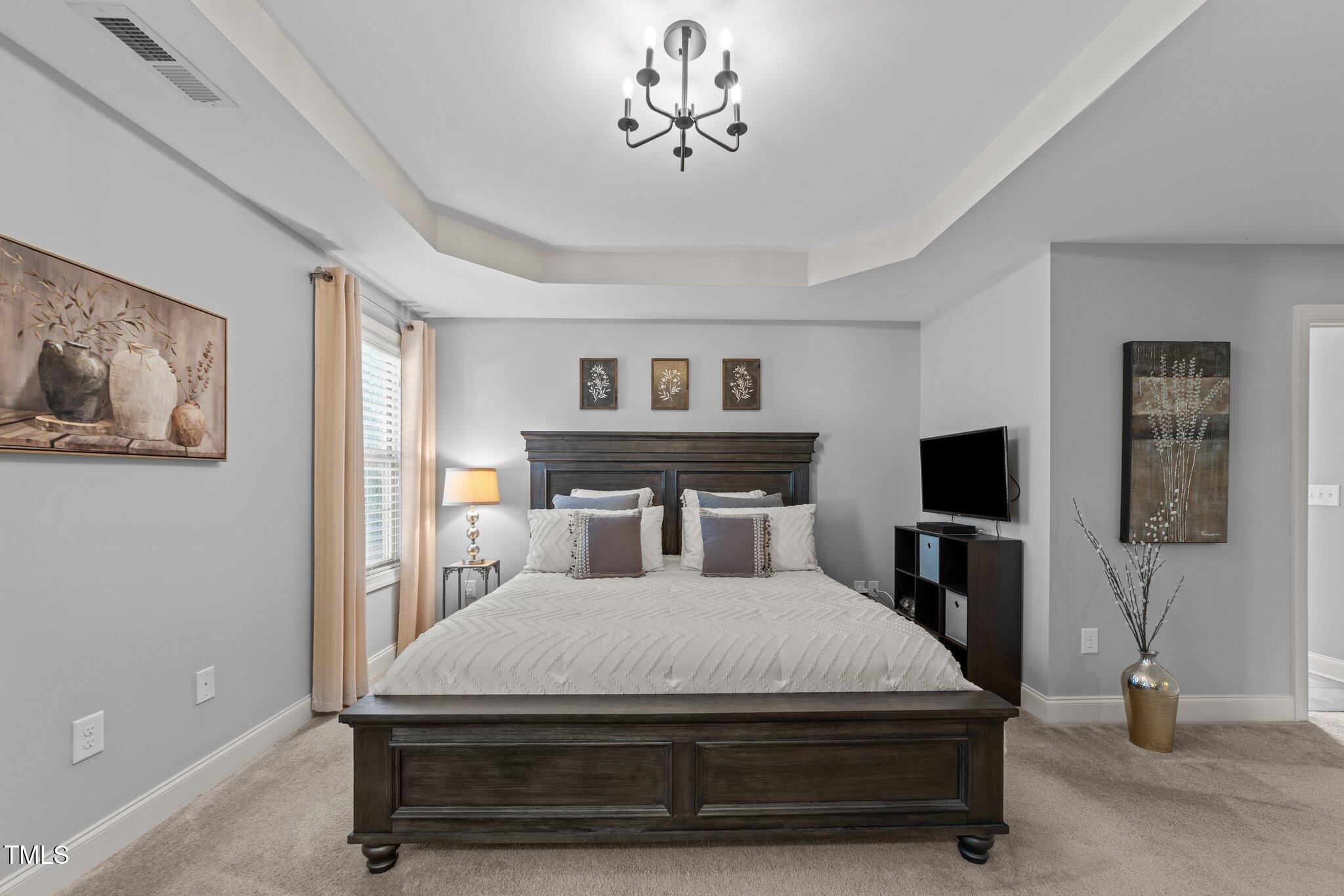 7520 Channery Way Raleigh, NC 27616 - Photo 23 of 47 a bedroom with a bed and a chandelier