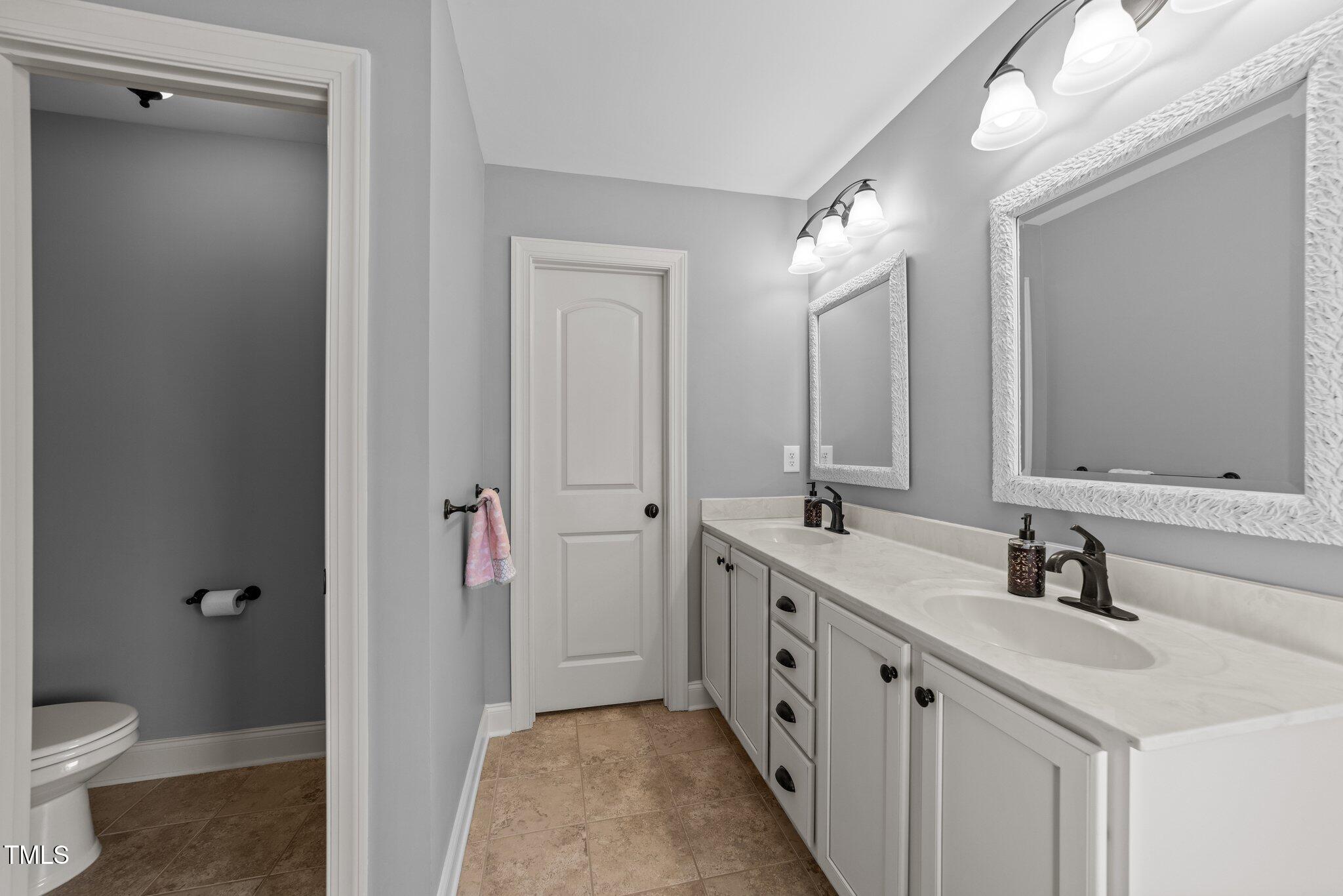 7520 Channery Way Raleigh, NC 27616 - Photo 24 of 47 a bathroom with a double vanity sink mirror and toilet