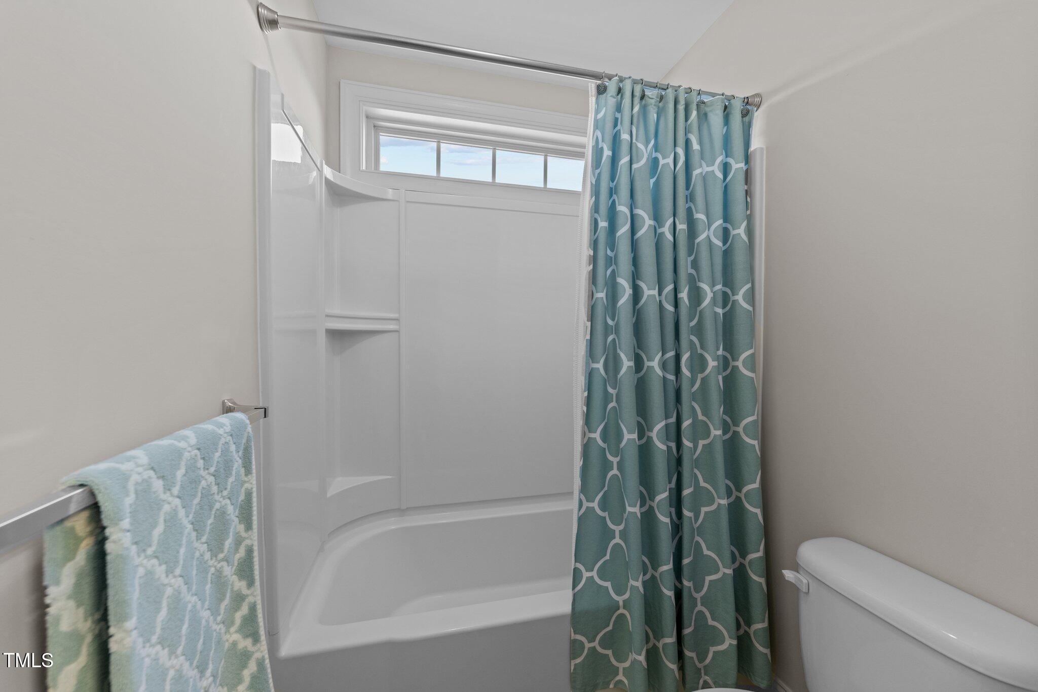 7520 Channery Way Raleigh, NC 27616 - Photo 31 of 47 a bathroom with a shower curtain and a toilet