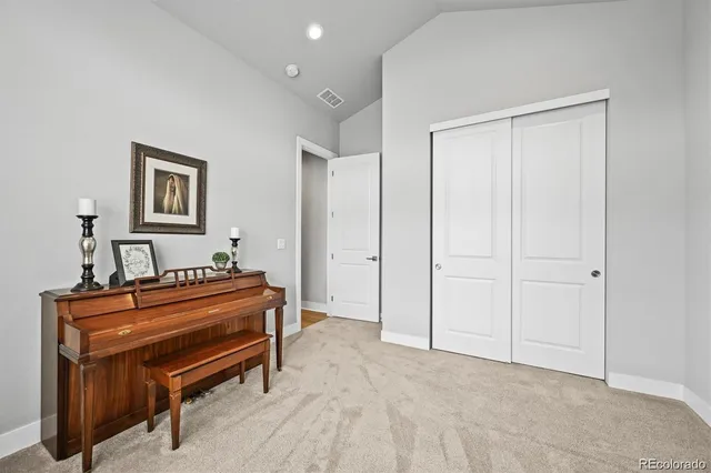 a view of a hallway with a piano and wooden floor