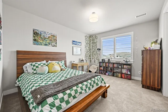 a bedroom with a bed painting and a large window