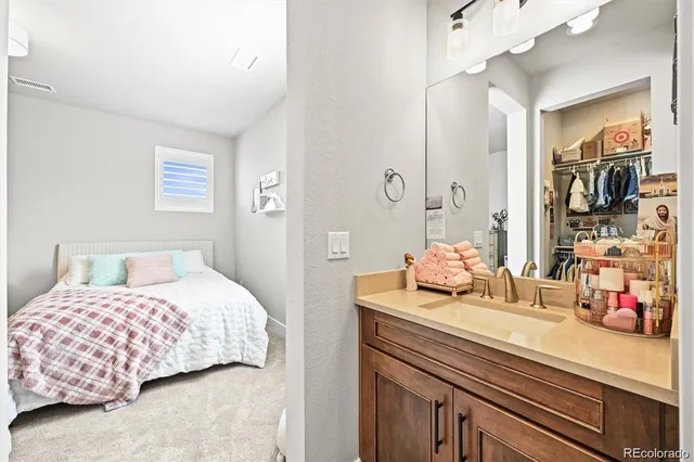 a bedroom with a bed and a large mirror on the dresser