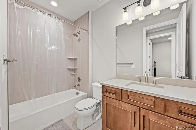 a bathroom with a sink a toilet a mirror and shower