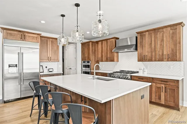 a kitchen that has a table chairs stainless steel appliances and cabinets