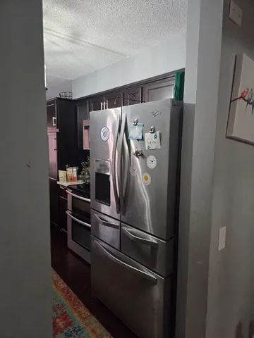 a metallic refrigerator freezer sitting in a kitchen