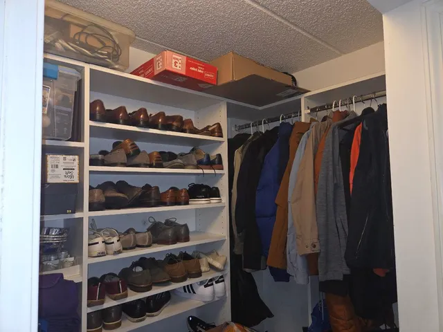 a view of walk in closet with clothes and shoes