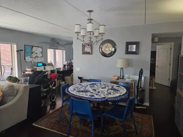 a view of a dining room and livingroom furniture a chandelier and wooden floor
