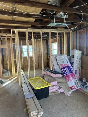 a view of walk in closet with wooden floor and windows