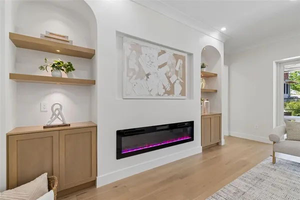 an empty room with wooden floor a ceiling fan and windows