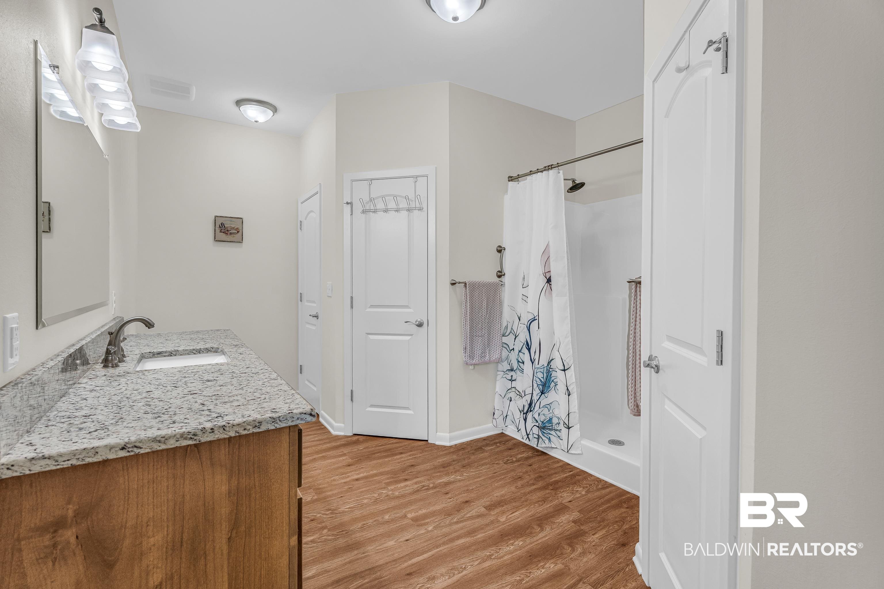 18255 Cactus Court Elberta, AL 36530 - Photo 26 of 53 Bathroom featuring a stall shower, vanity, and light wood-style floors